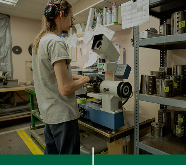 Un affûteur et monteur de couteaux, membre de l'équipe de Moulures 4D, qui utilise une machine à affûter dans l'atelier de l'entreprise.